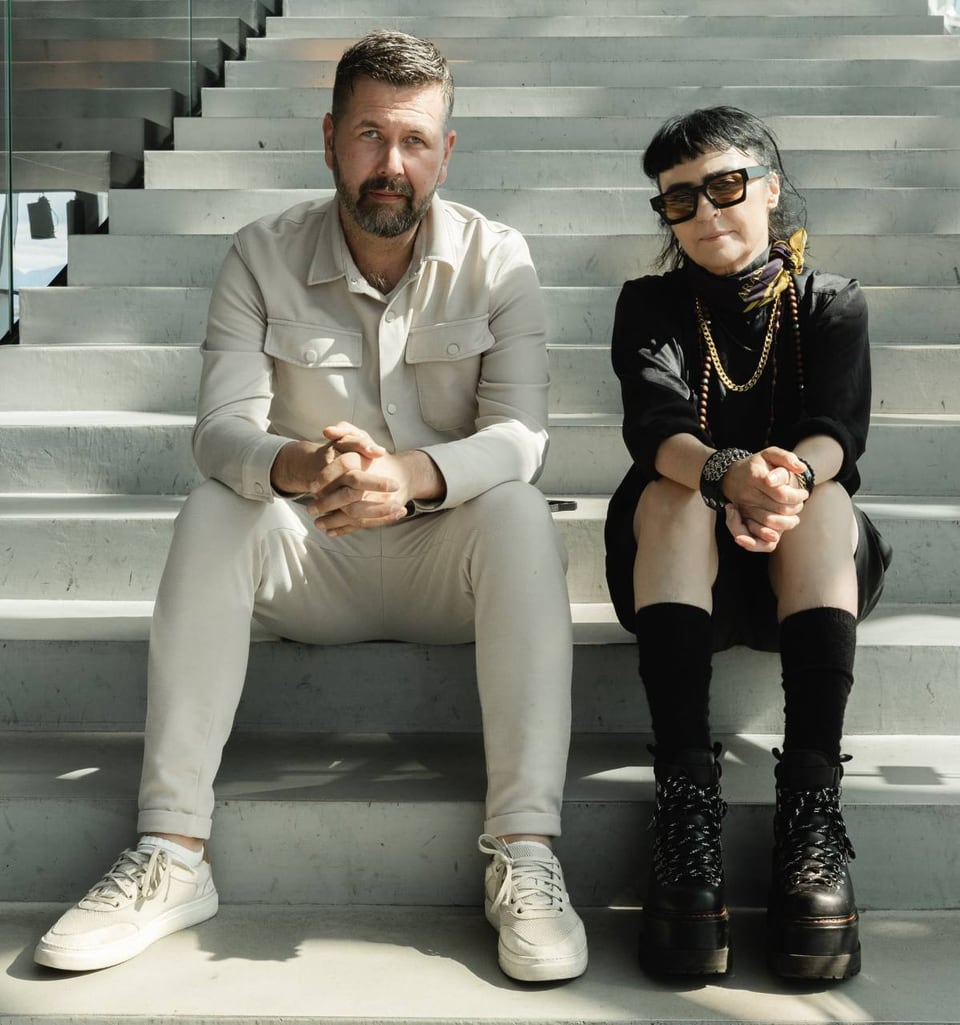 Two people sit on wide concrete steps.